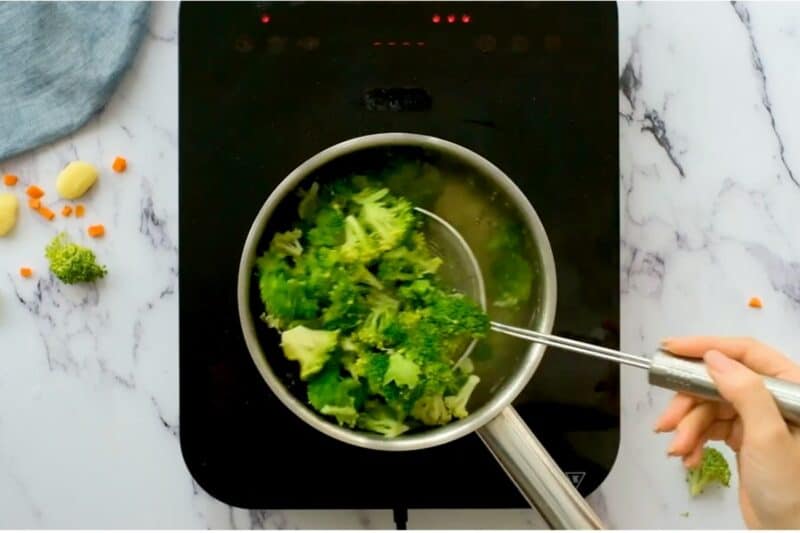 boiling broccoli florets in hot water and taking them out.