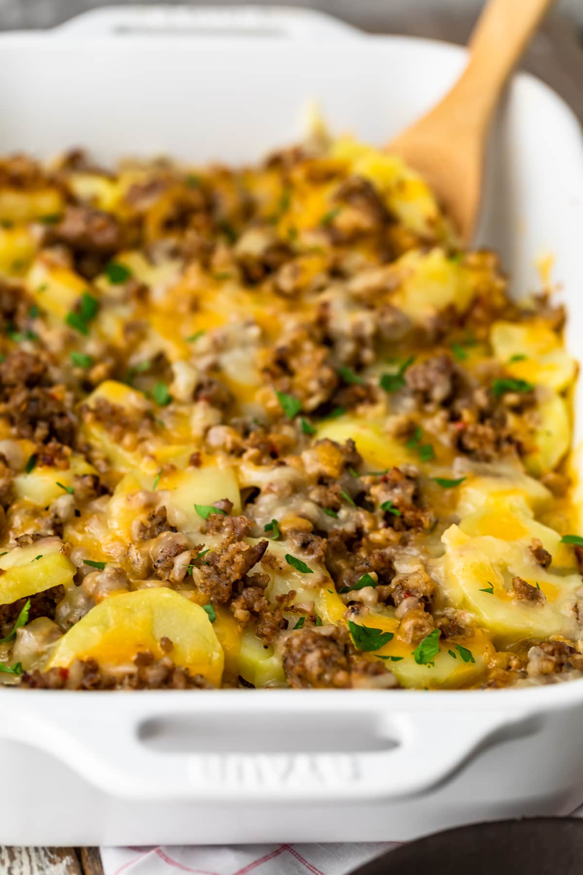 sausage, cheese, potatoes, and onion in a white baking dish