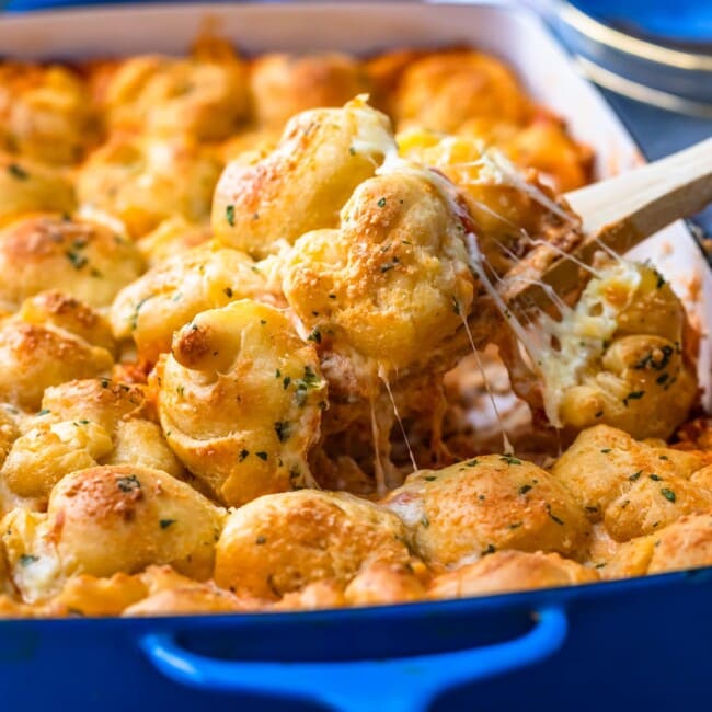 Cheesy biscuits and gravy baked in a blue dish.