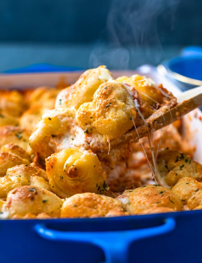 Pizza Casserole is the perfect cheese-filled dish to serve for a fun dinner! This pepperoni pizza casserole recipe is made with layers of cheese, sauce, and pepperonis, then topped with balls of pizza dough and brushed with garlic butter. You're left with a DELICIOUS garlic bread pizza bake that everyone will love!