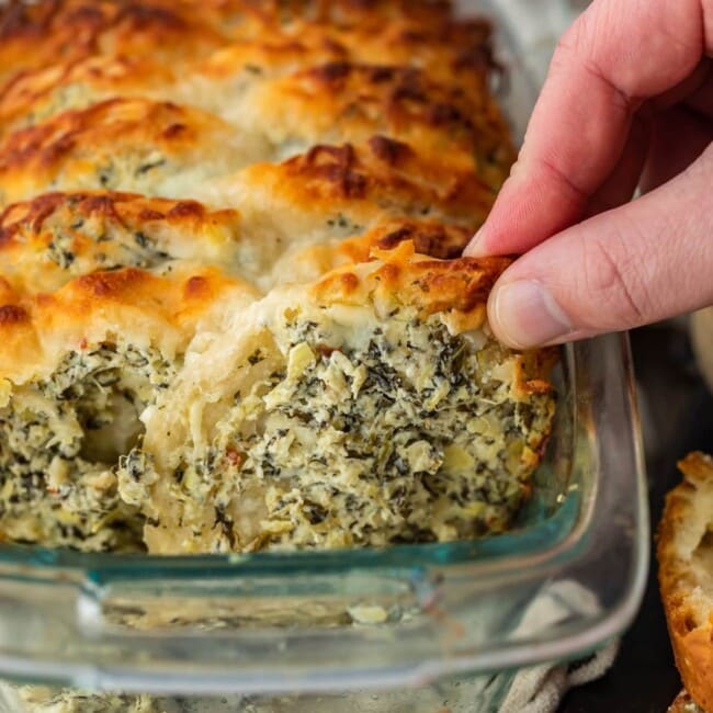Spinach Artichoke Dip Pull Apart Bread is the perfect way to get that delicious spinach artichoke flavor in the form of an easy bread. Make it as an appetizer or a tasty side dish to serve with your favorite dinners. This pull apart bread recipe is super simple and super flavorful!