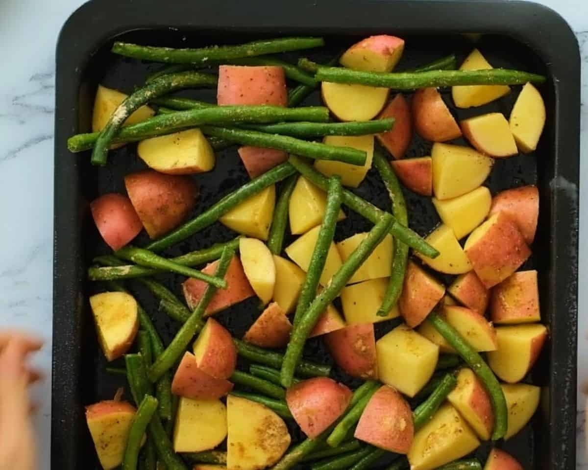 Green beans and potatoes on a roasting pan.