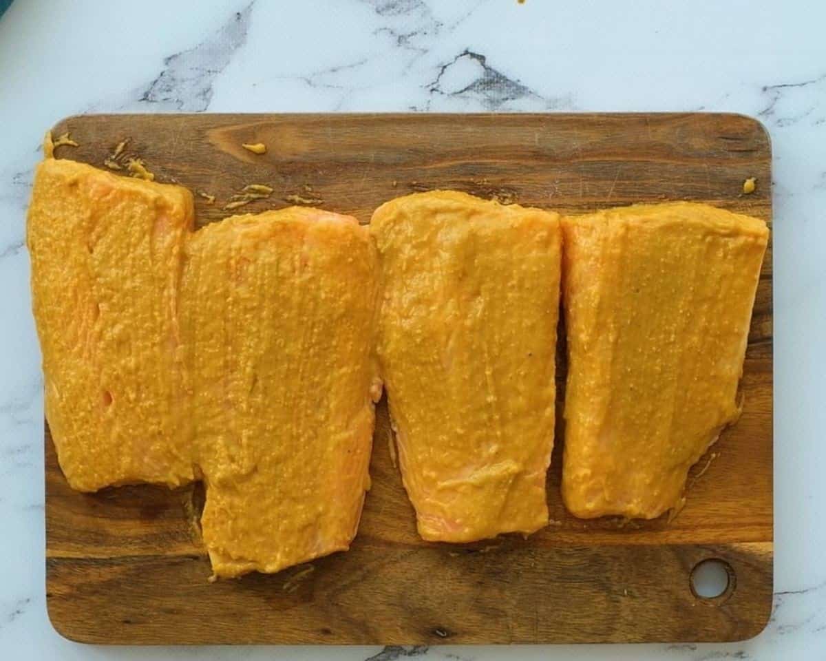 Salmon filets covered with mustard seasoning.