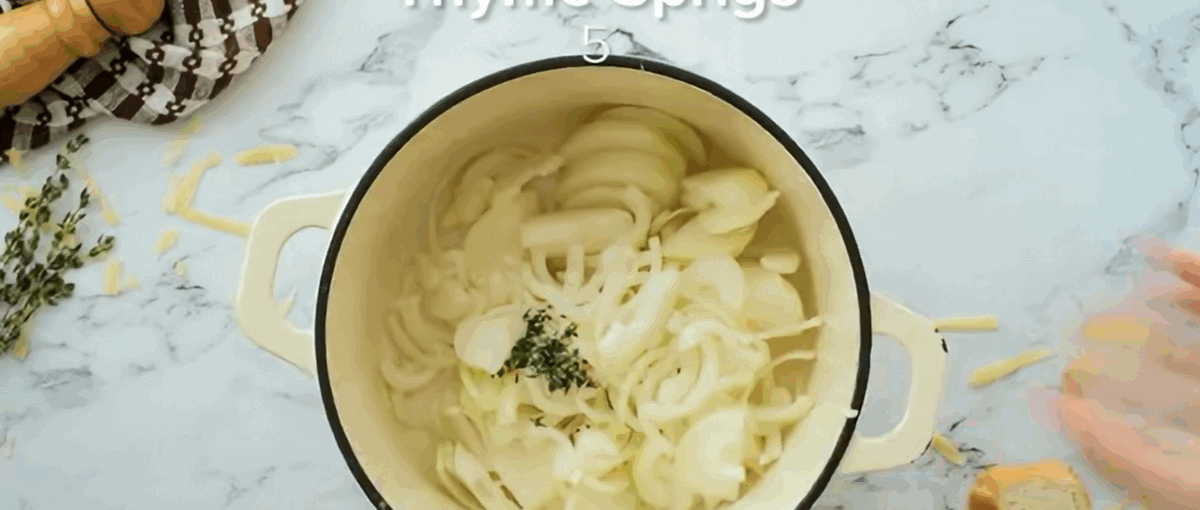 Adding sliced onions to a Dutch oven.