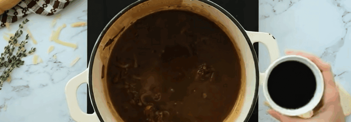 Adding the liquid ingredients to the pot of onions. 