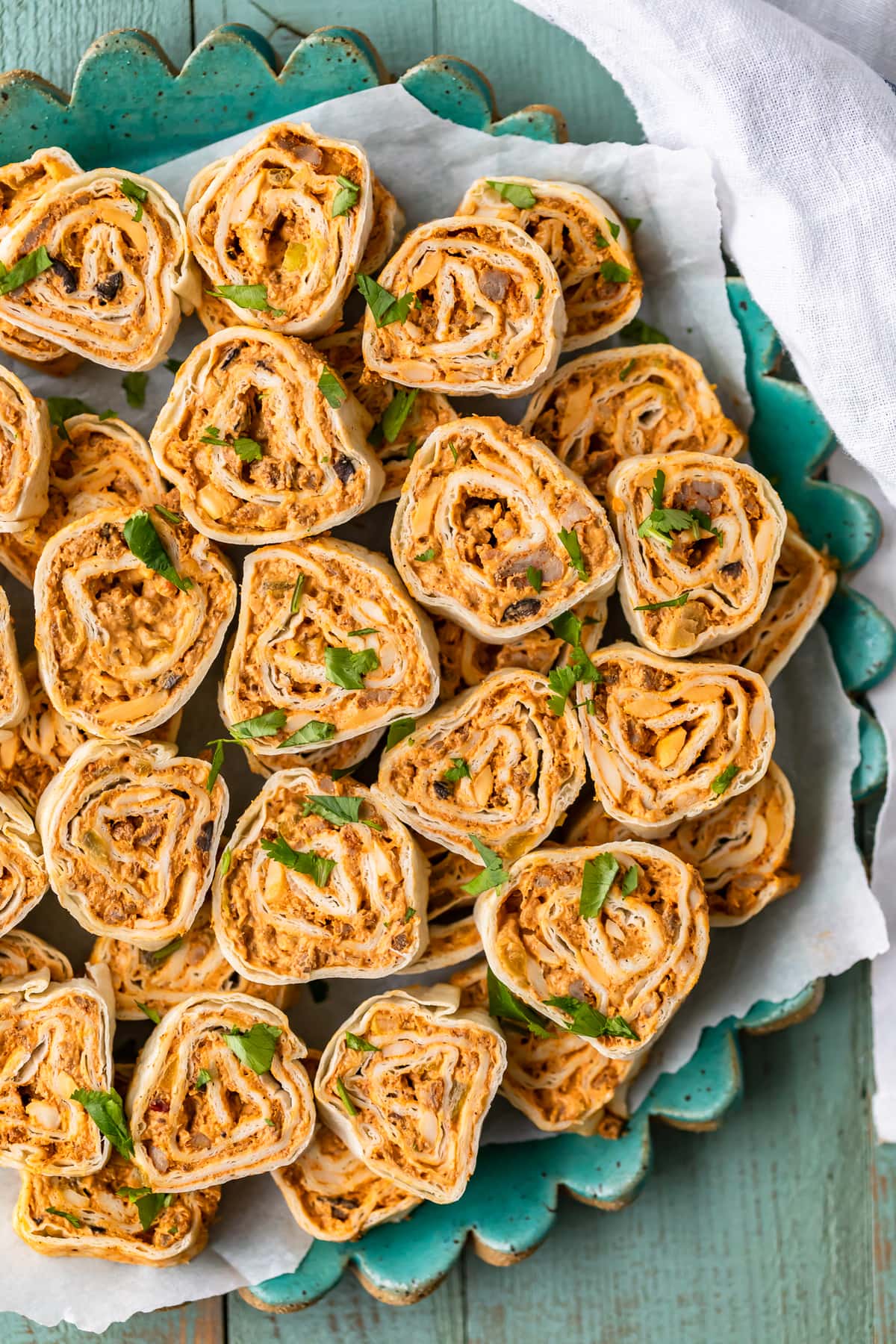 Mexican Pinwheels are a super simple and super tasty appetizer for any occasion. These Southwest Sausage Pinwheels are easy to make and require hardly any work at all. These sausage cream cheese pinwheels have all my favorite Mexican inspired flavor in one bite. Just as easy as any tortilla roll ups appetizer! a plate of mexican pinwheels viewed from above.