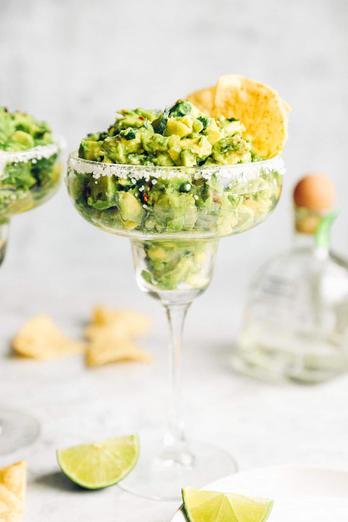Tequila guacamole in a margarita glass with corn chips. 