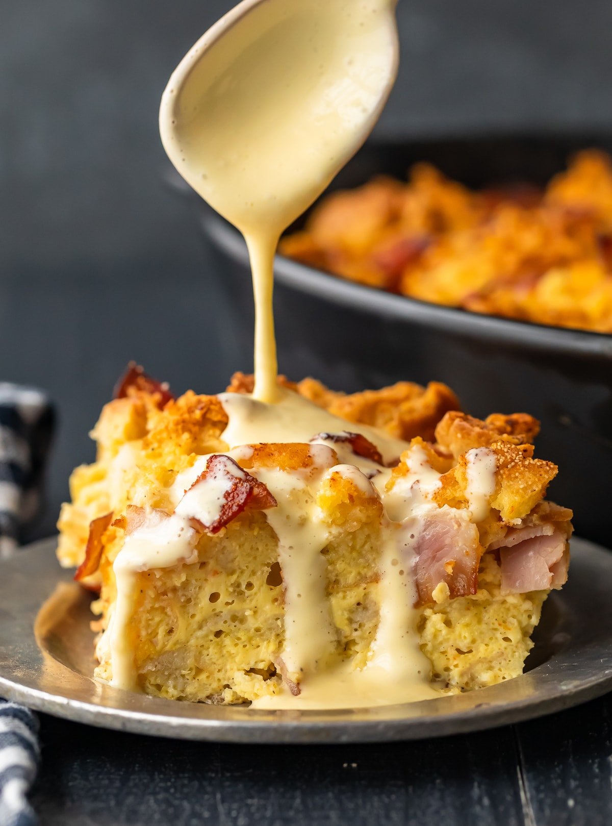 eggs benedict casserole topped with hollandaise sauce