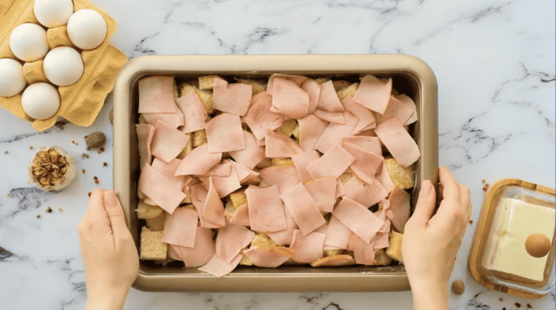 ham on top of english muffin pieces in a casserole dish.