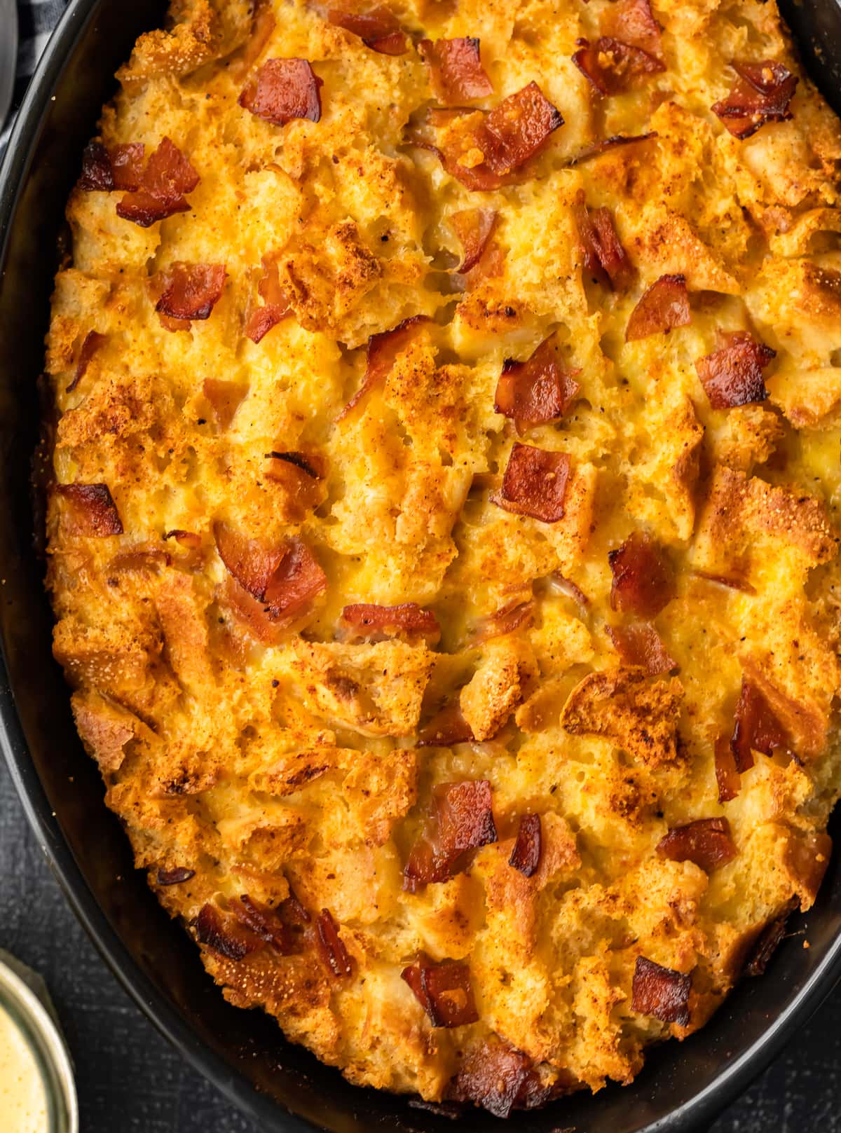 casserole dish filled with baked eggs, english muffins, and ham