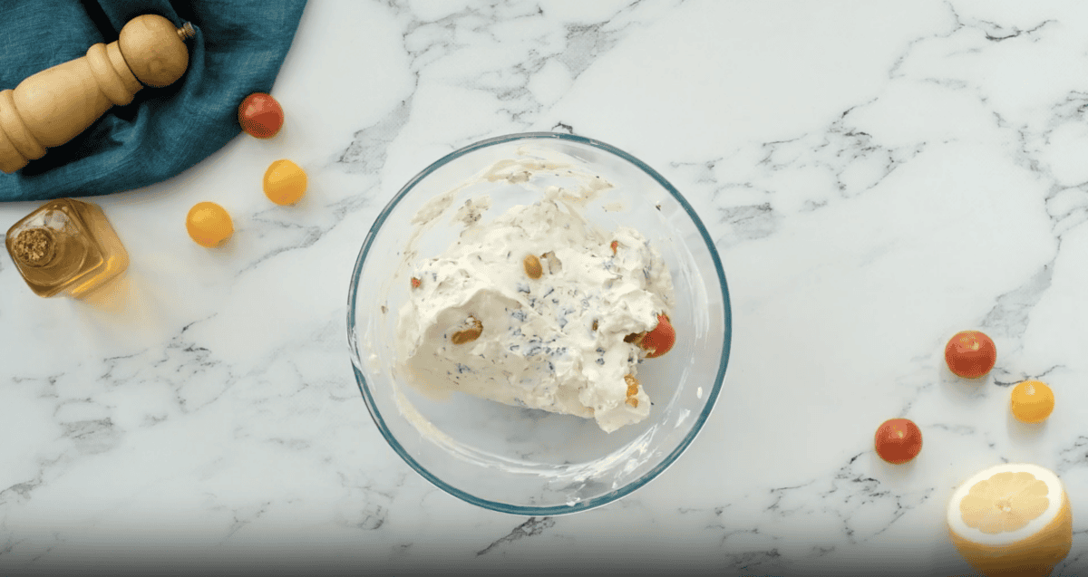 goat cheese dip with tomatoes in a glass bowl.