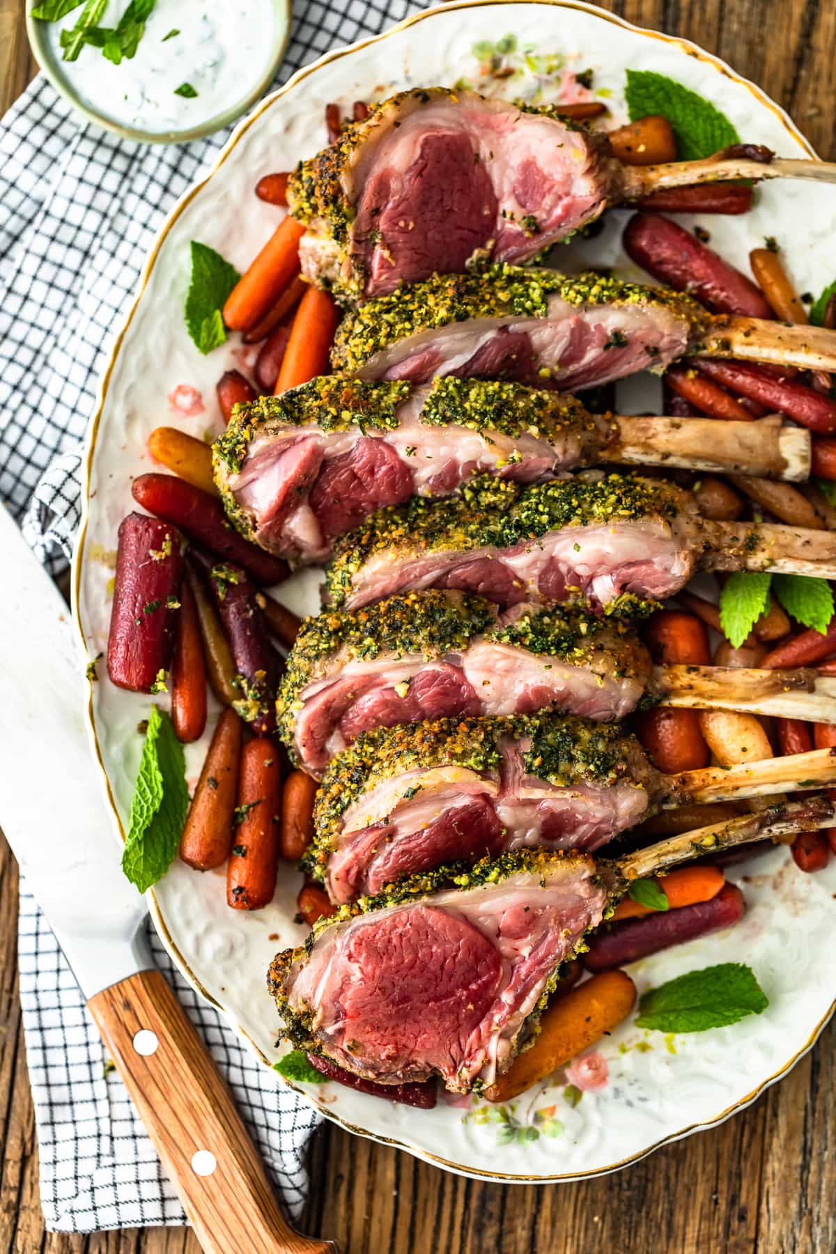 roast rack of lamb on a plate of carrots