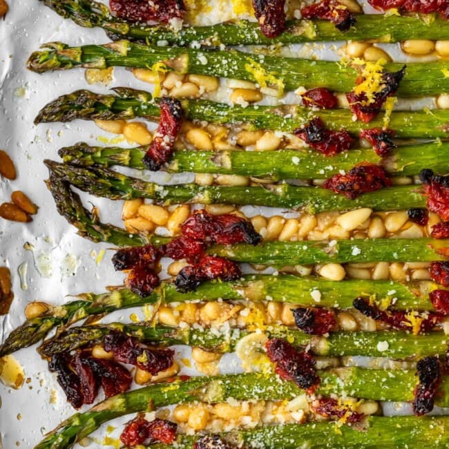 Oven Roasted Asparagus with sun dried tomatoes, pine nuts, garlic, and more is a delicious Mediterranean-inspired side dish fit for any occasion. This easy roasted asparagus recipe is quick to make yet filled with flavor! Add this asparagus side dish to your holiday meals, or just to your weeknight dinners. Either way, it's sure to be a hit!