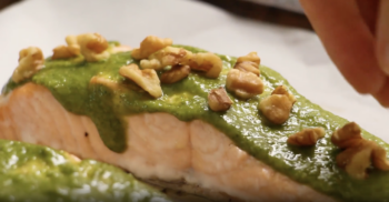 baked salmon topped with pesto and walnuts.