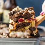 A person scooping up a slice of a sandwich in a pan, next to a bowl of St. Patrick's Day punch. - 6