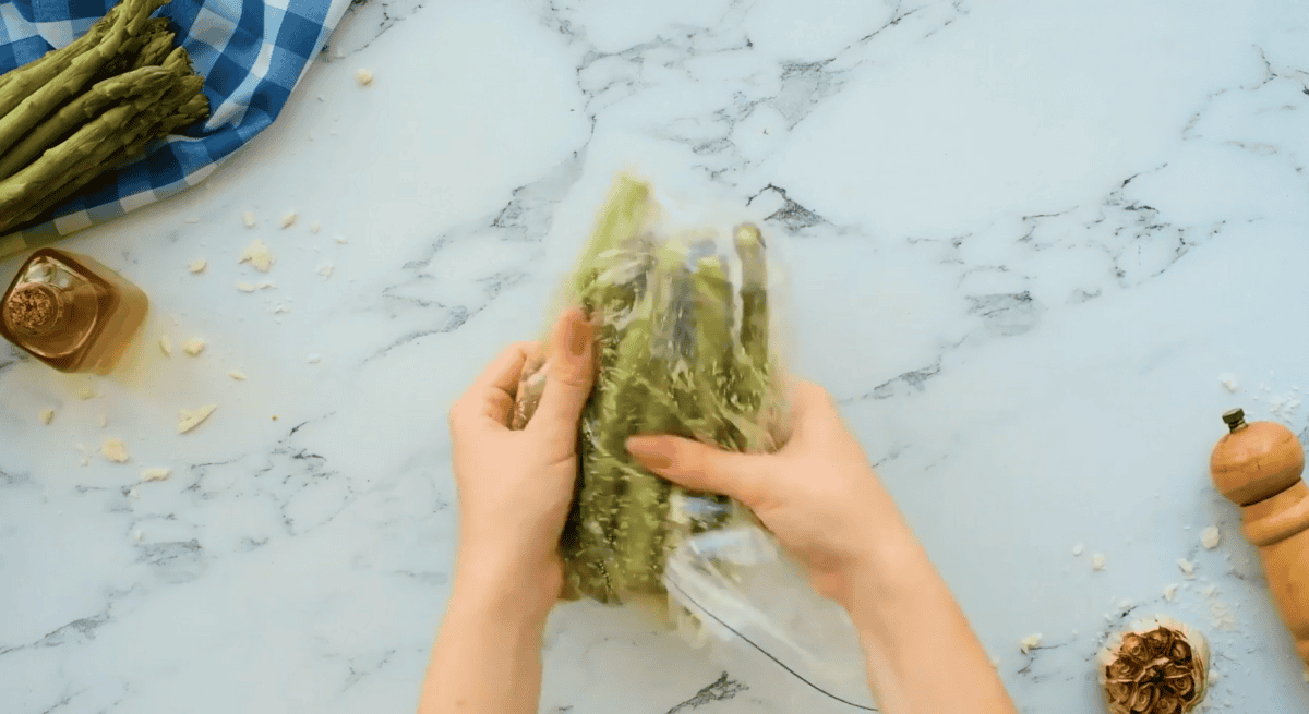 asparagus added to the plastic bag and being massaged with the flavoring. 