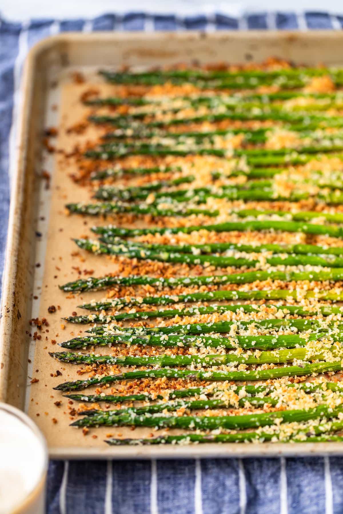 asparagus lined up on a baking tray