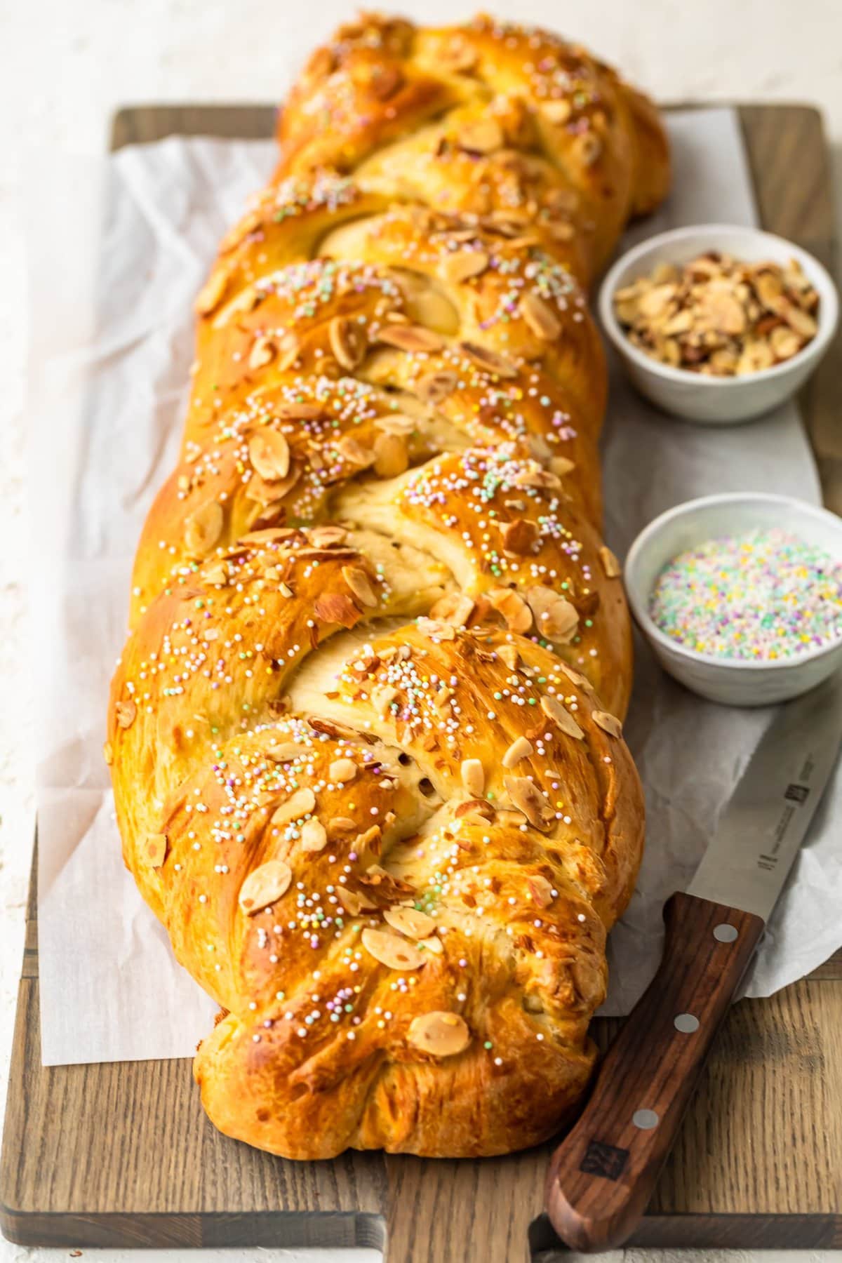 a loaf of braided bread on a wooden cutting board