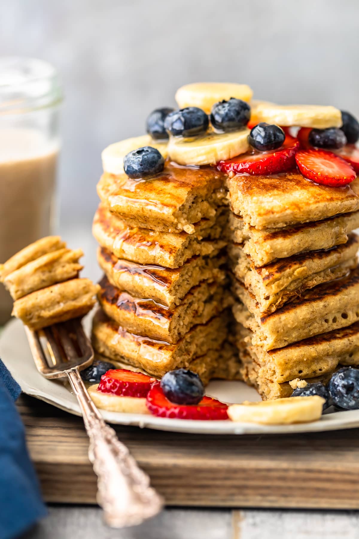 banana pancakes stacked on a plate with bite cut out