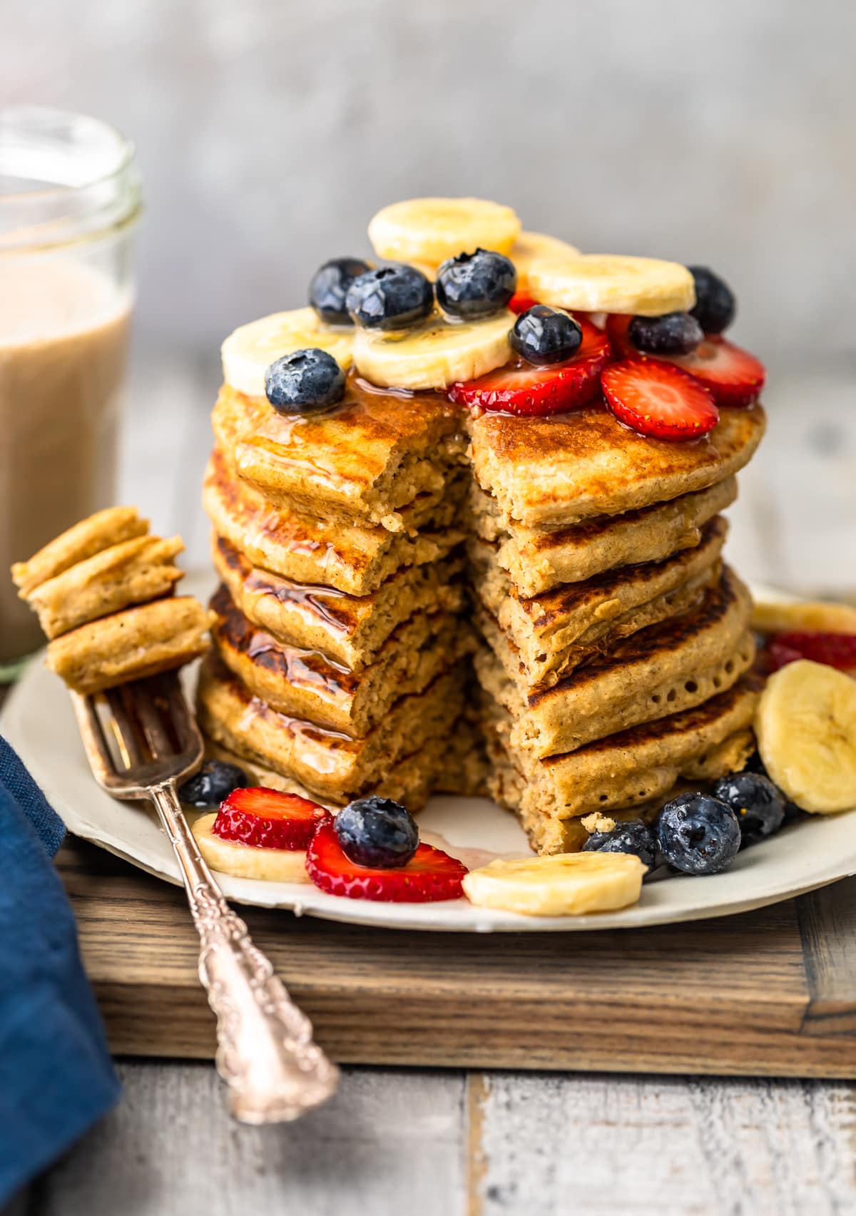 easy banana pancakes recipe with fresh fruit and honey with bite cut out