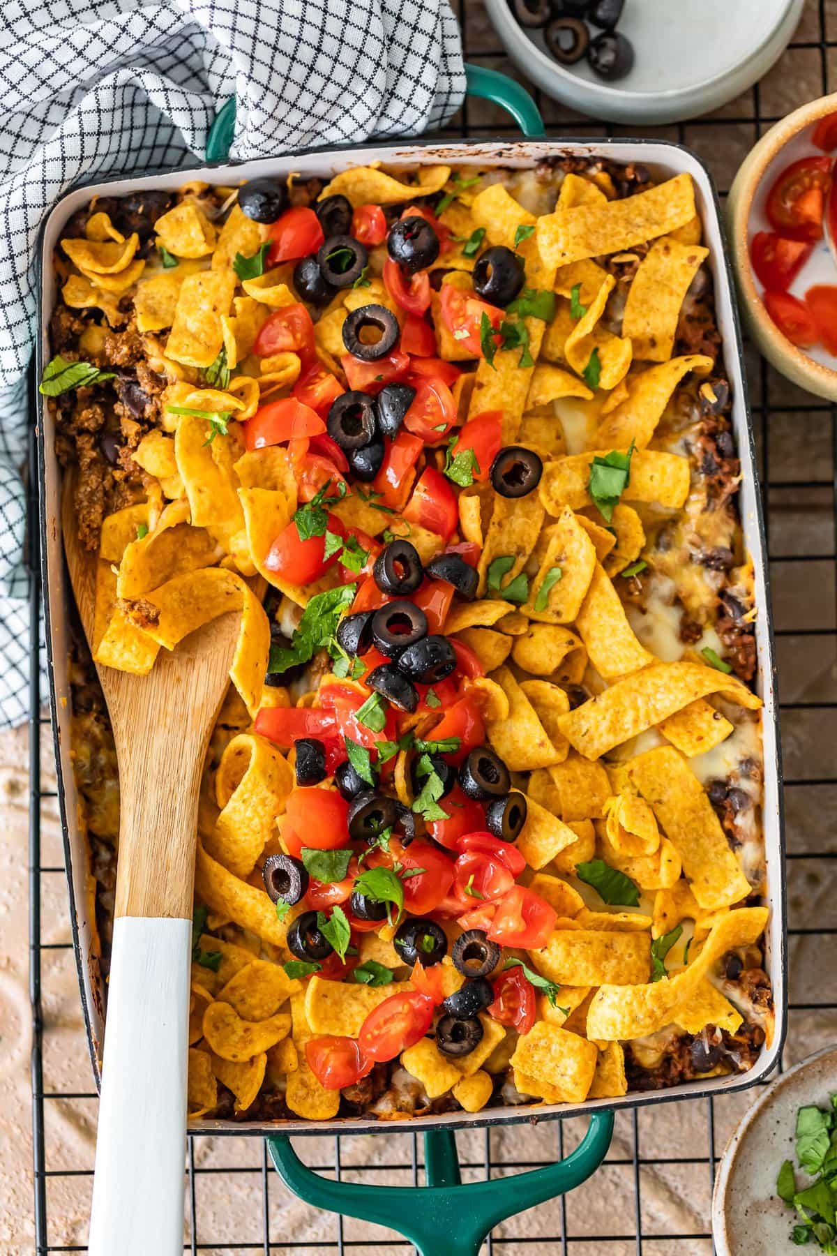 fritos, tomatoes, olives, beef in a baking dish