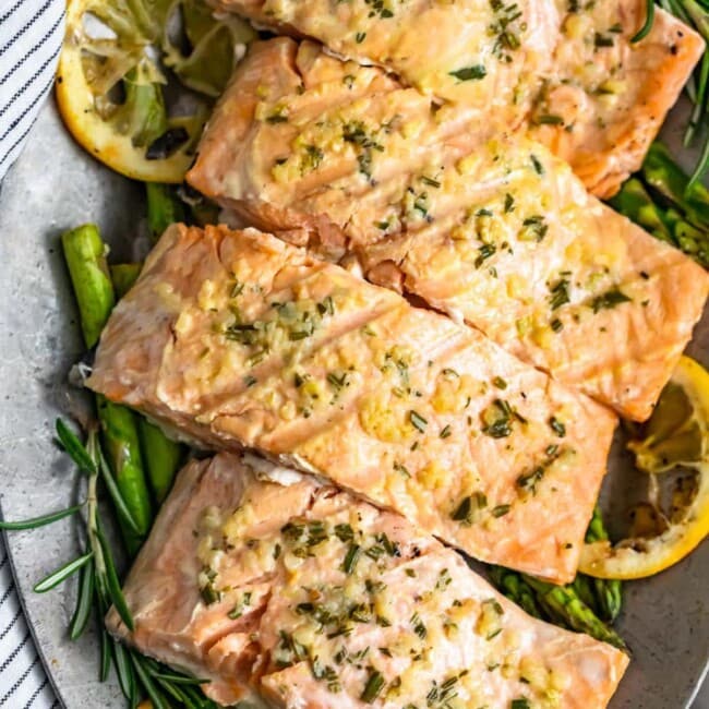 Garlic Butter Salmon is a simple and healthy dish you'll want to be making all summer long! This easy grilled salmon recipe is one of the best and most flavorful. The garlic lemon butter salmon is so light and tasty, and it is just perfect paired with our grilled lemon butter asparagus!