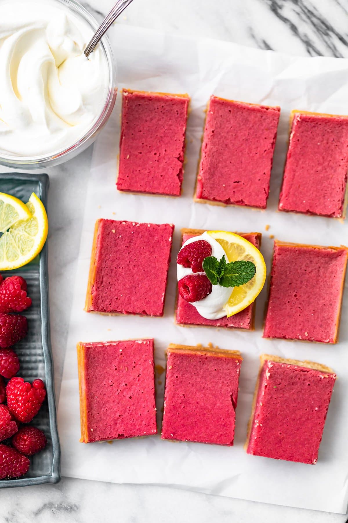 raspberry bars arranged on a sheet of parchment paper