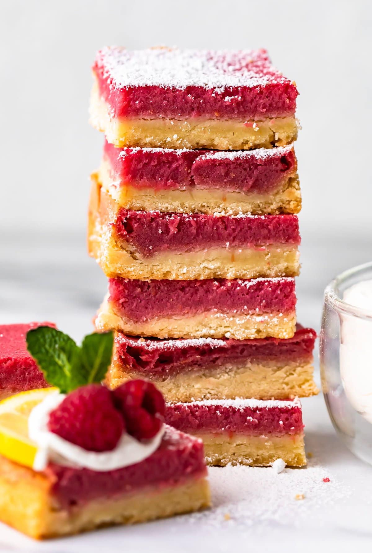 dessert bars stacked up and topped with powdered sugar