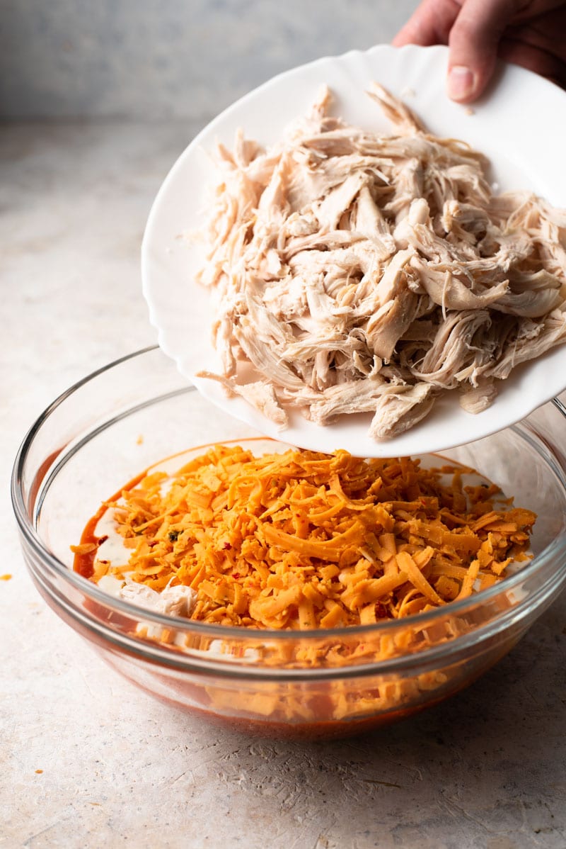 Shredded chicken in a bowl to make buffalo chicken dip