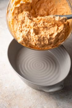A bowl of mashed potatoes with a spoonful of buffalo chicken dip.