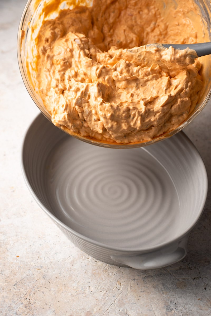 Transferring a buffalo chicken dip into a baking dish