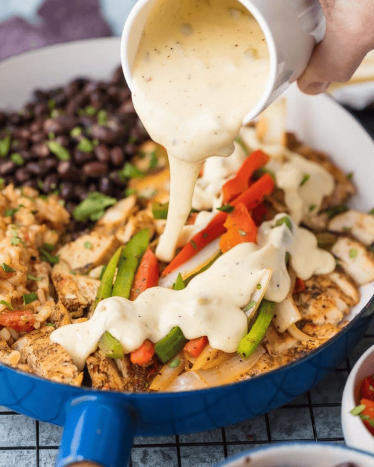 This easy Chicken Fajitas recipe has quickly become a favorite around here. AQueso Smothered Chicken Fajita Recipe with all the best ingredients! Pouring a white cheese sauce over chicken fajitas.