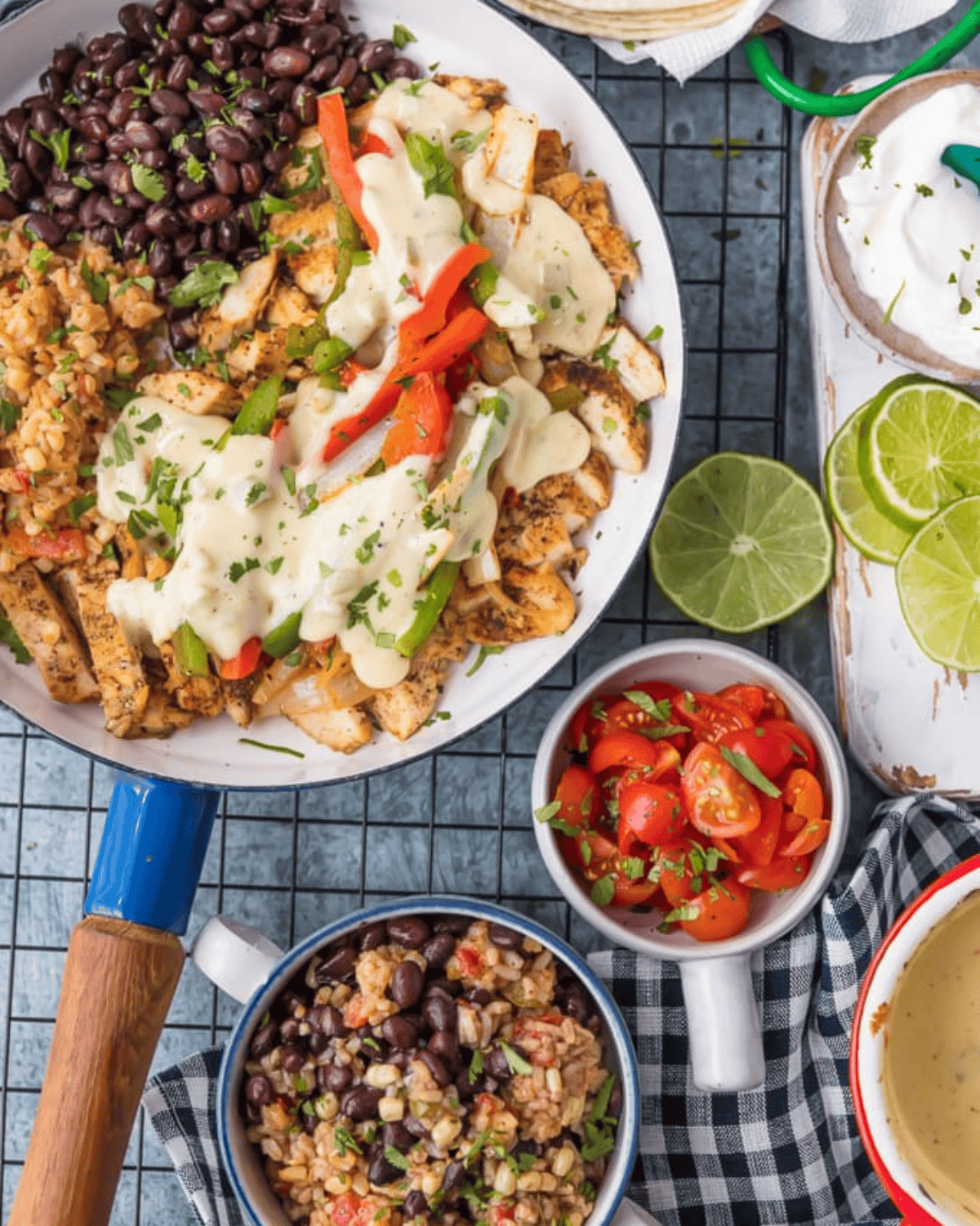 This easy Chicken Fajitas recipe has quickly become a favorite around here. AQueso Smothered Chicken Fajita Recipe with all the best ingredients! Chicken fajitas covered in cheese sauce, a bowl of cut-up tomatoes and lime slices.