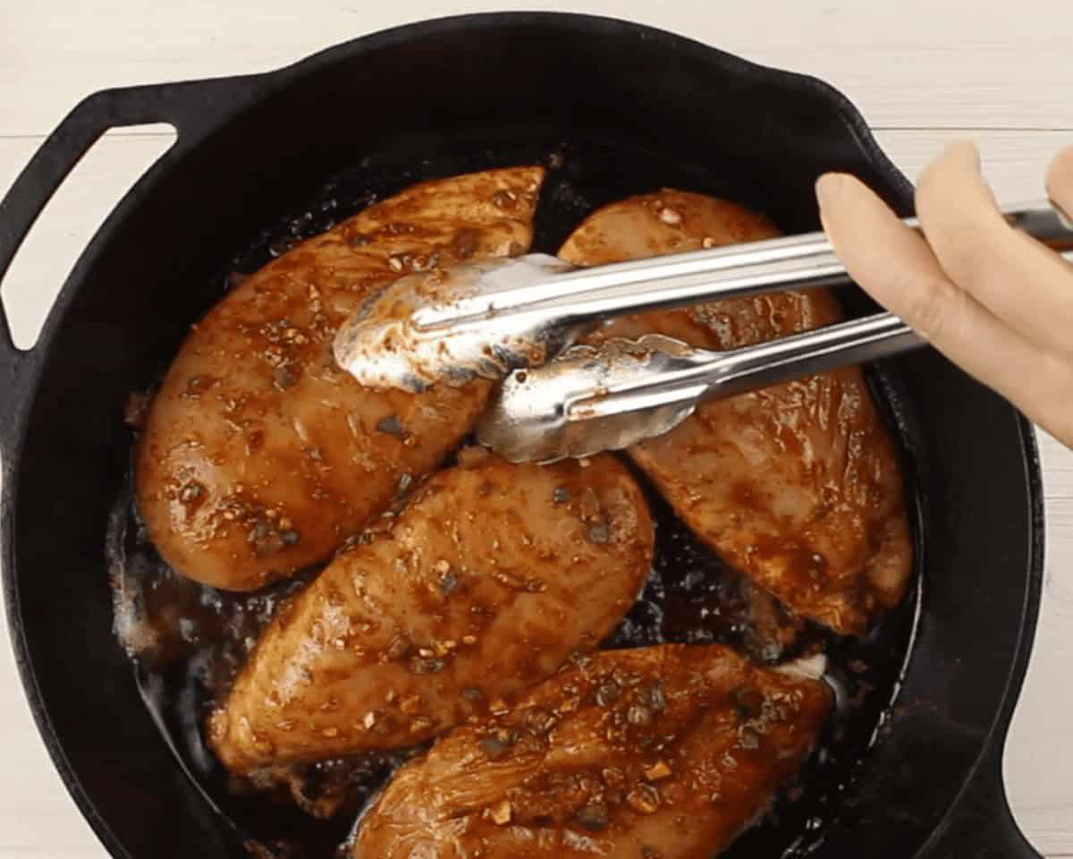 Cooking chicken in a black skillet.