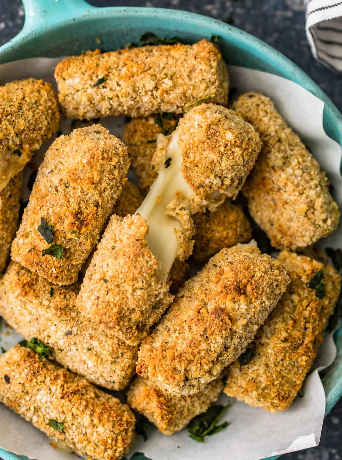 Close up of baked mozzarella cheese sticks in a serving bowl