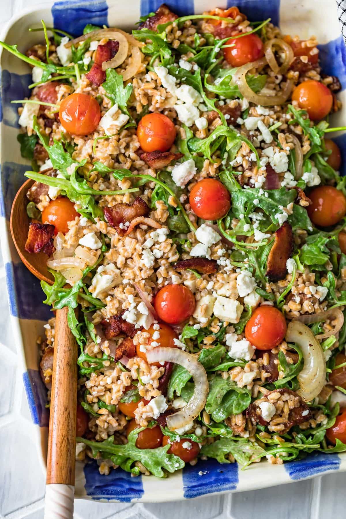 salad topped with tomatoes, bacon, feta, and more