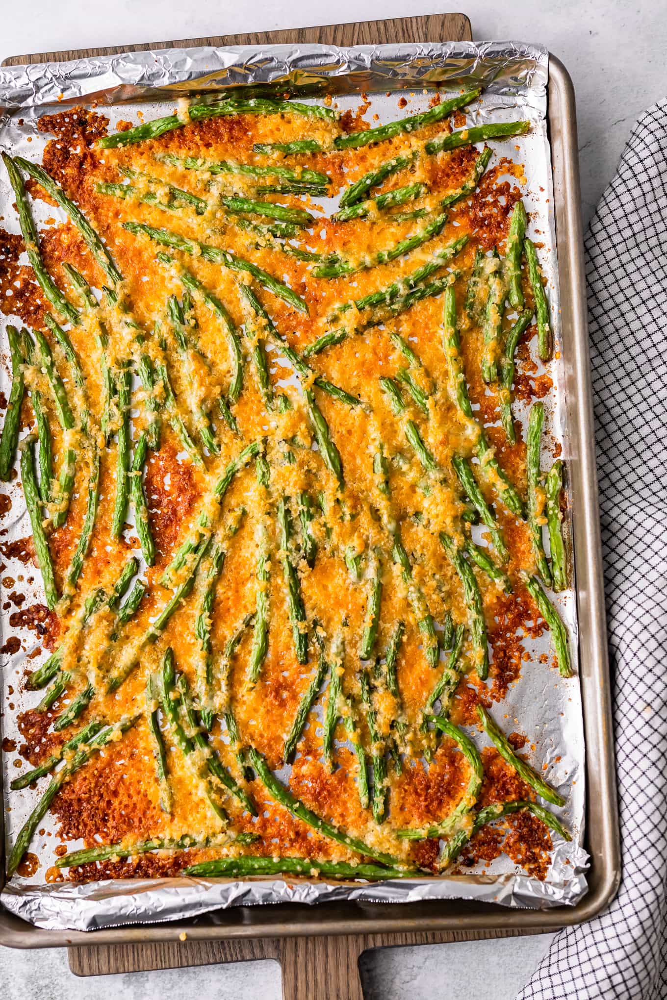 cooked green beans with cheese on a sheet pan
