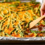 spatula lifting up green beans from pan