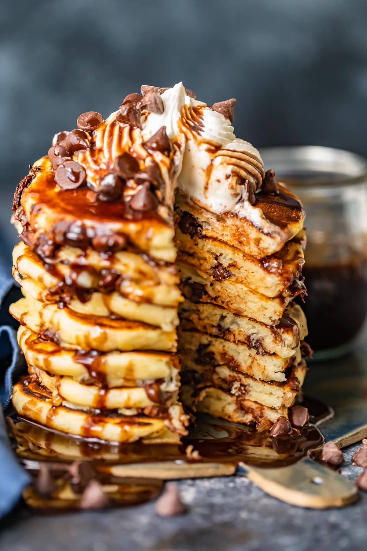 A stack of chocolate chip pancakes with a wedge cut out