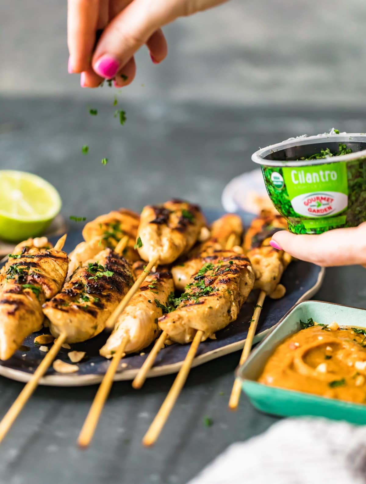 sprinkling cilantro over grilled chicken