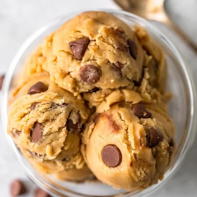 a top view of scooped chocolate chip edible cookie dough in a bowl