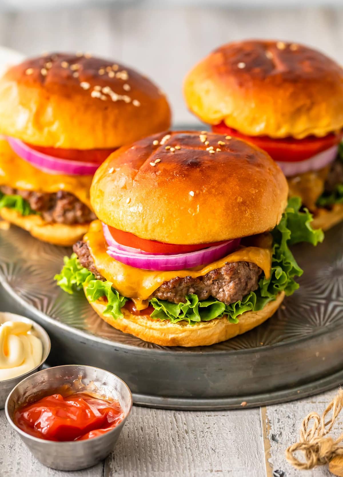 broiled hamburgers on buns with cheese and toppings