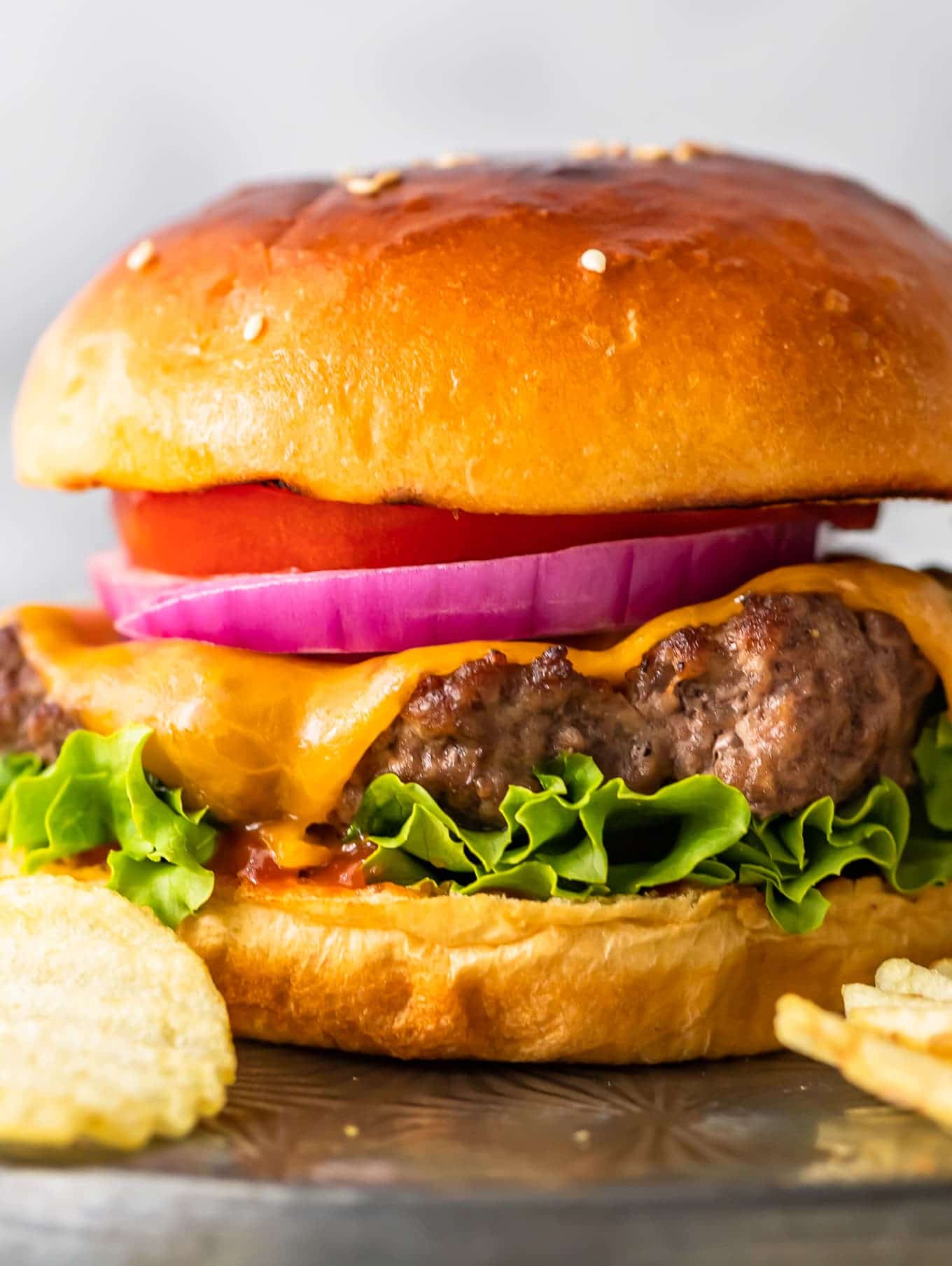 close up on cheeseburger topped with onions and tomato