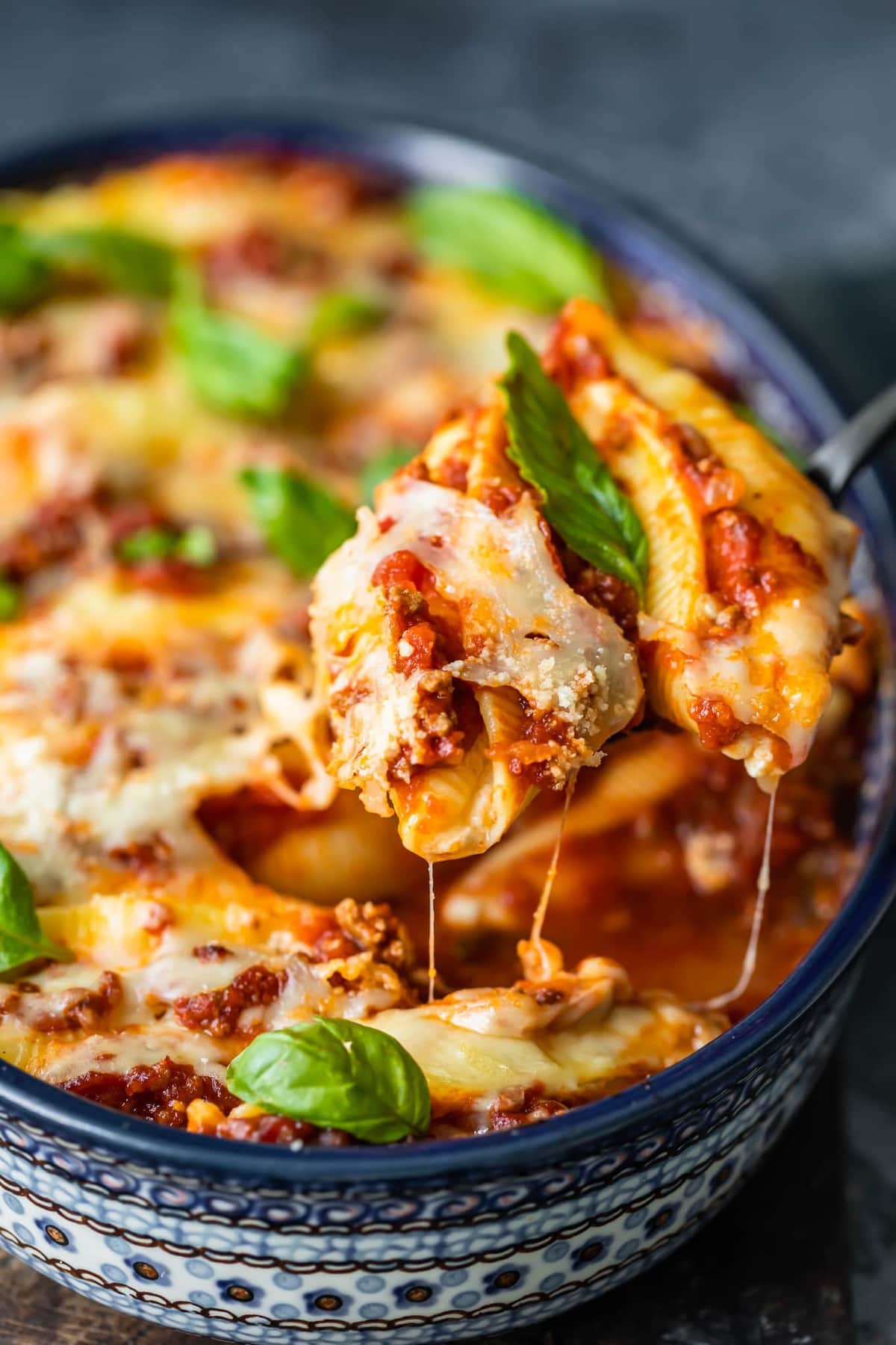 close up image of pasta shells stuffed with cheese and topped with meat sauce