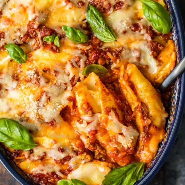 Cheesy stuffed shells with basil leaves.