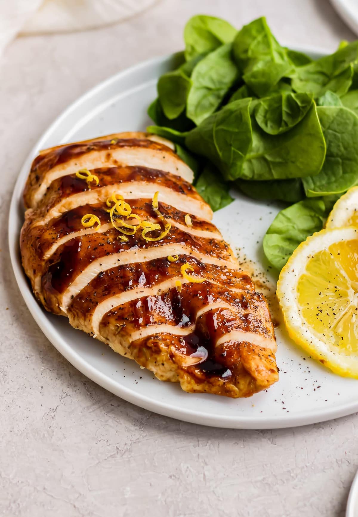 sliced honey balsamic chicken with spinach and lemon