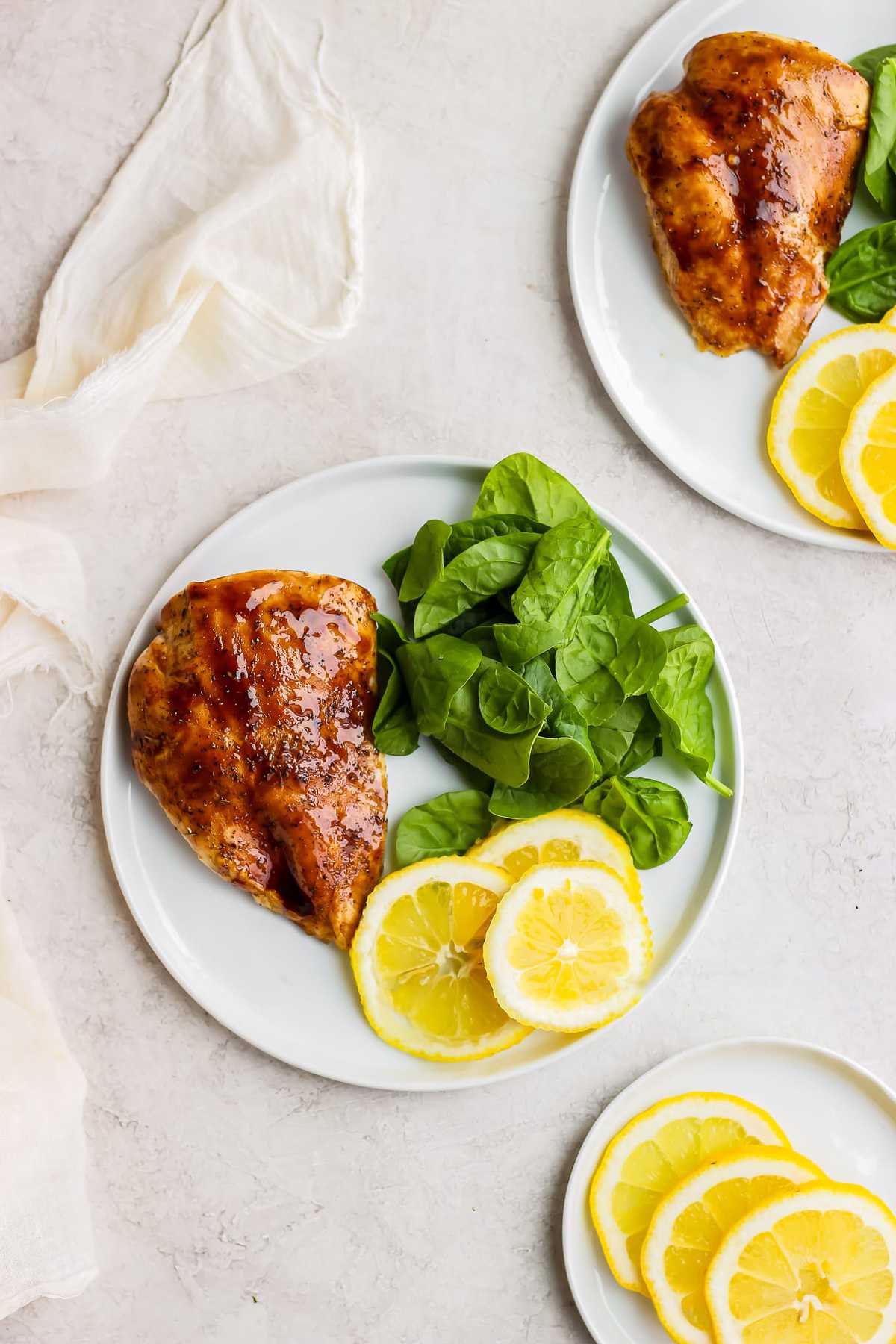 plate of chicken, spinach, and lemon slices