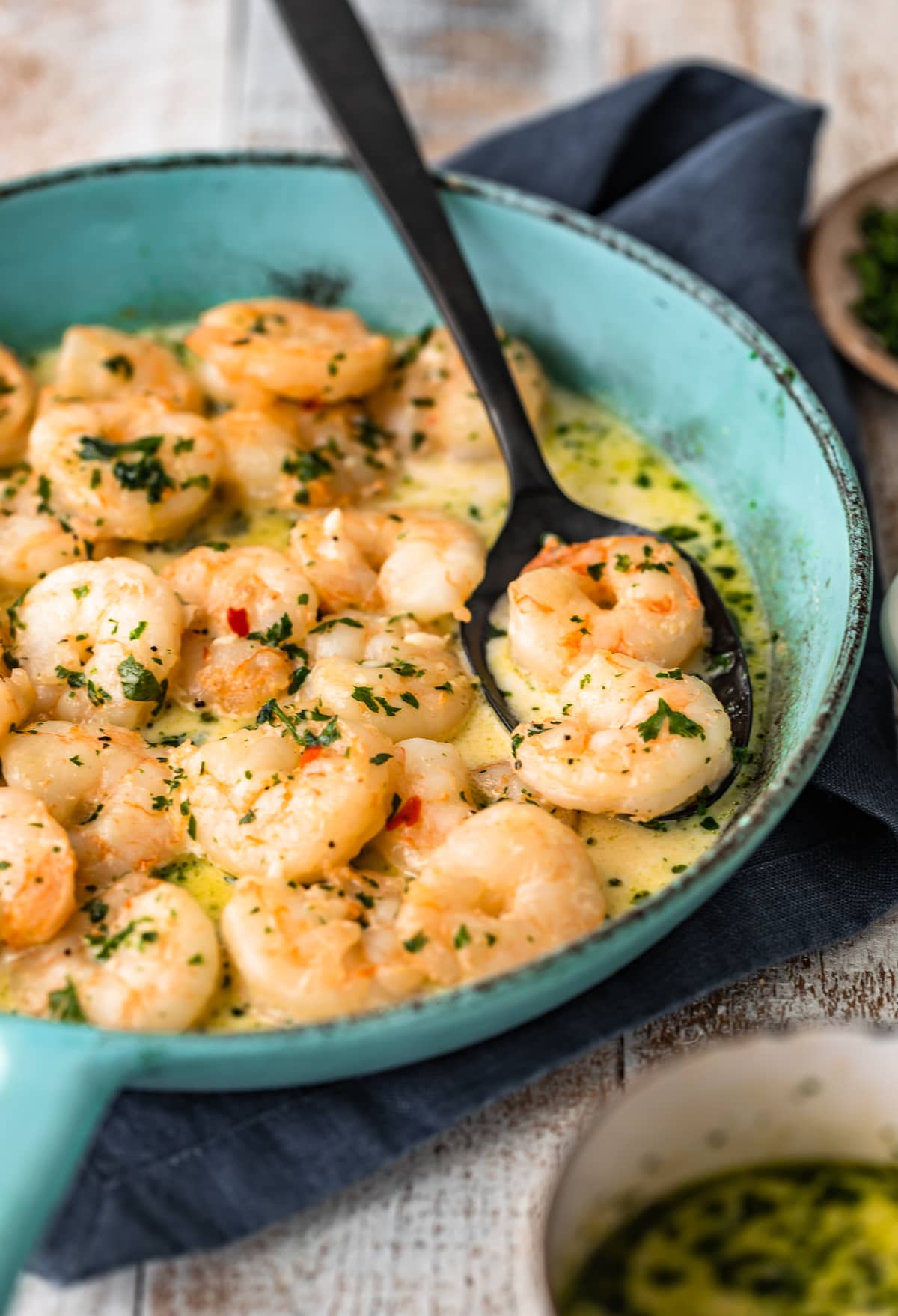 spicy garlic shrimp in cream sauce in turquoise skillet