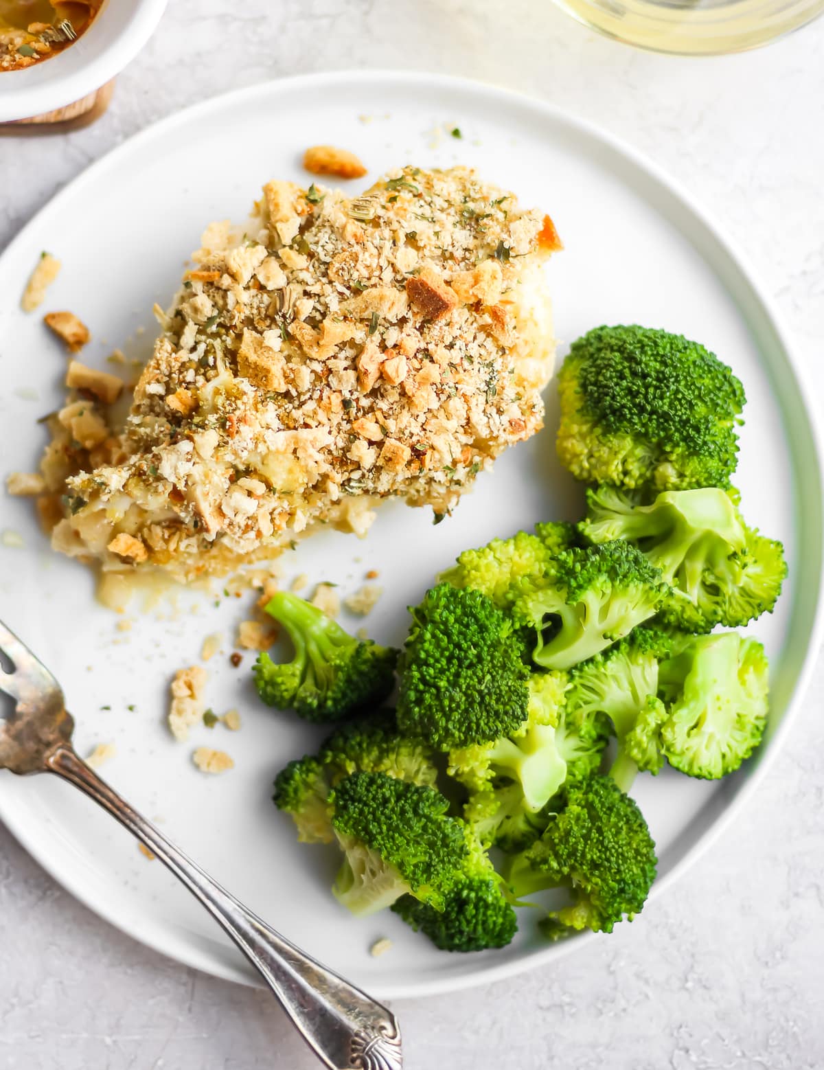 a piece of chicken on a plate with broccoli