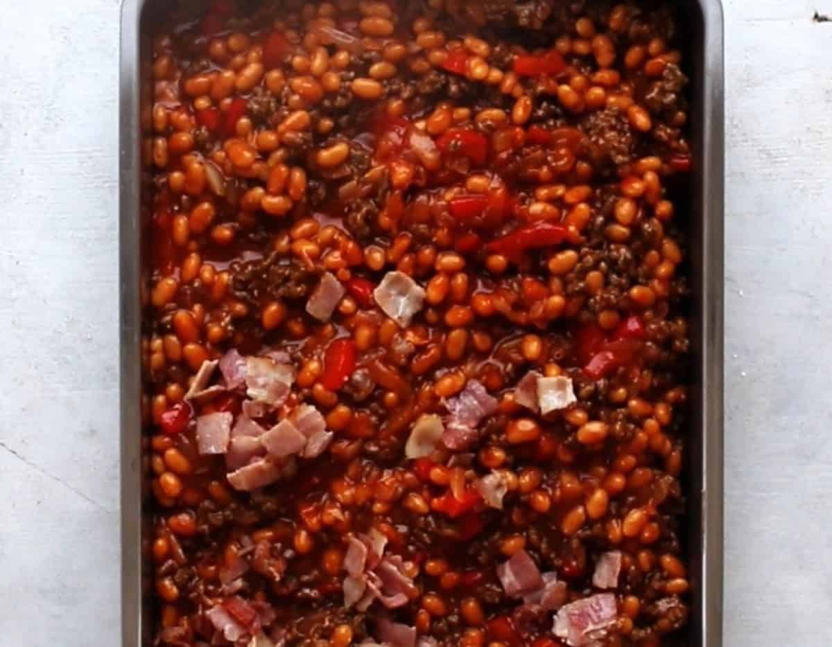 BBQ baked beans with bacon in a baking dish.